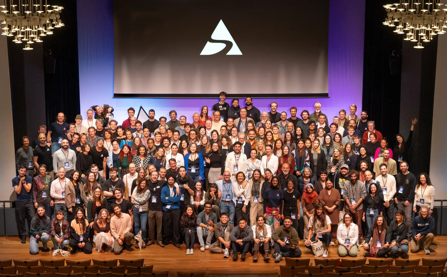 Group photo of the ALPS Conference 2026 speakers, attendees and crew on the stage of the Kultur & Kongresshaus Aarau, under the ALPS logo on the screen
